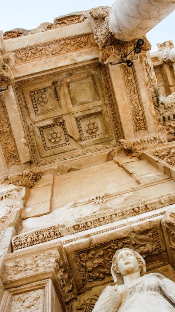 From below of Roman building with statue of Arete and decor on partially destroyed wall in Ephesus Turkey