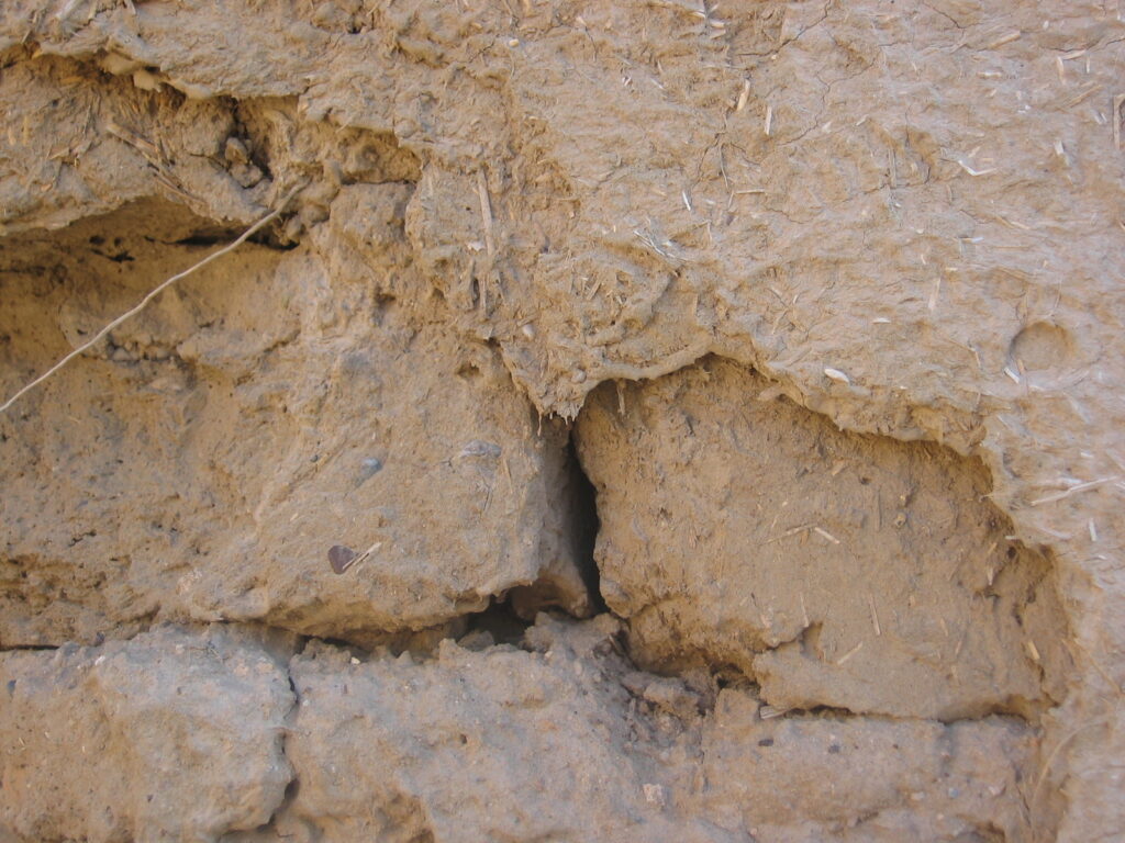 Photographie d'un mur en briques crues avec un enduit en argile, Syrie