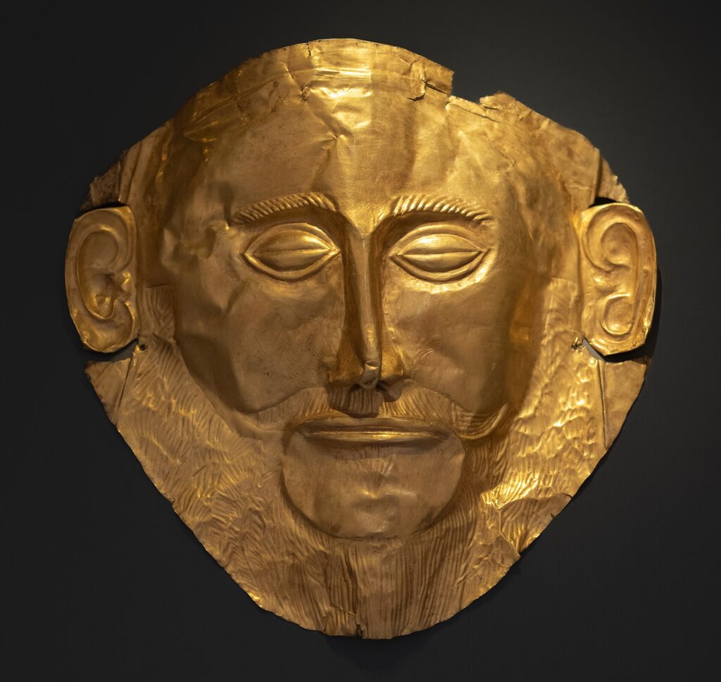 Masque mortuaire en or repoussé retrouvé dans la tombe V du cercle A à Mycènes. Vers 1600-1500 avant J.-C. Athènes, Musée national archéologique d'Athènes - Wikipedia Commons
